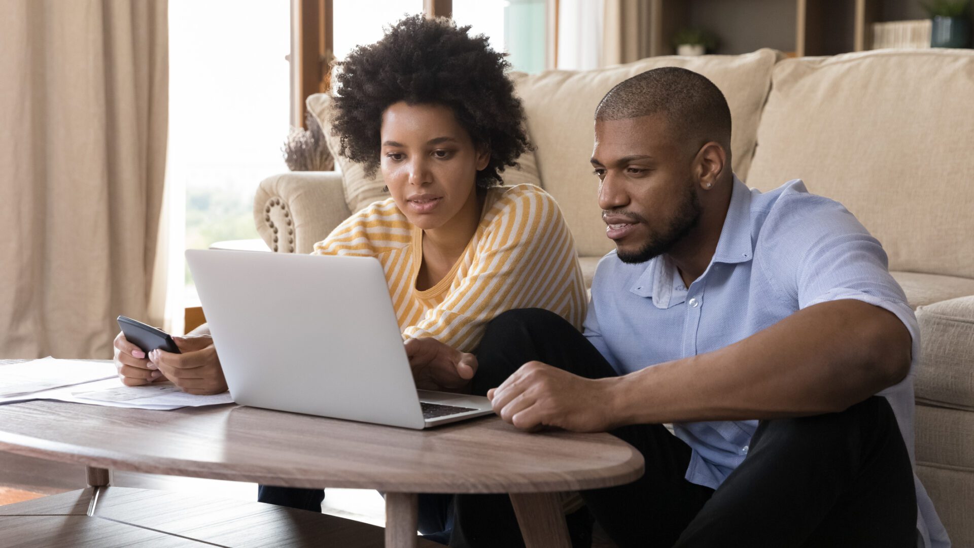 Couple reviewing home survey report on laptop